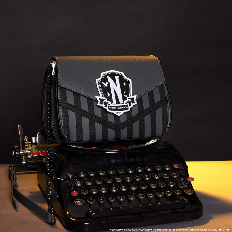 Image of our Wednesday Crossbody sitting on top of an old school typewriter